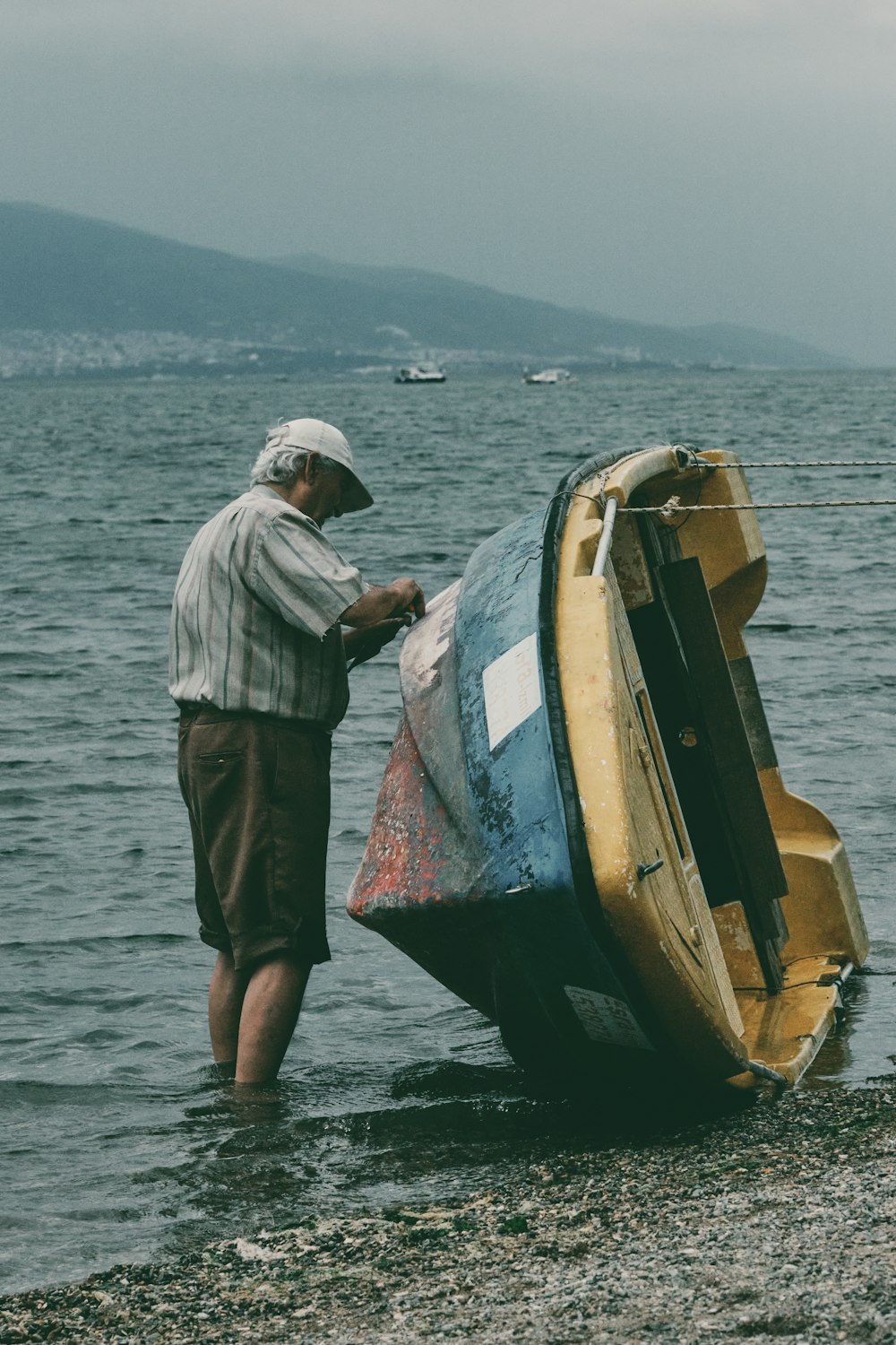 Un uomo in piedi accanto a una barca in cima a uno specchio d'acqua
