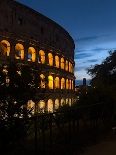 A vibrant photo of Verona’s historic Arena lit up at dusk, bustling with visitors.