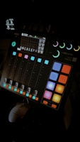 Mixing console with colorful lights and audio waveforms on screens.
