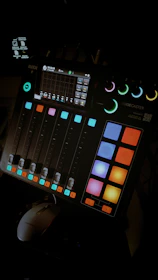 Studio mixing console with colorful lights during a music production session.