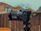 Close-up of a DSLR camera on a tripod capturing candid moments at an open-air party.