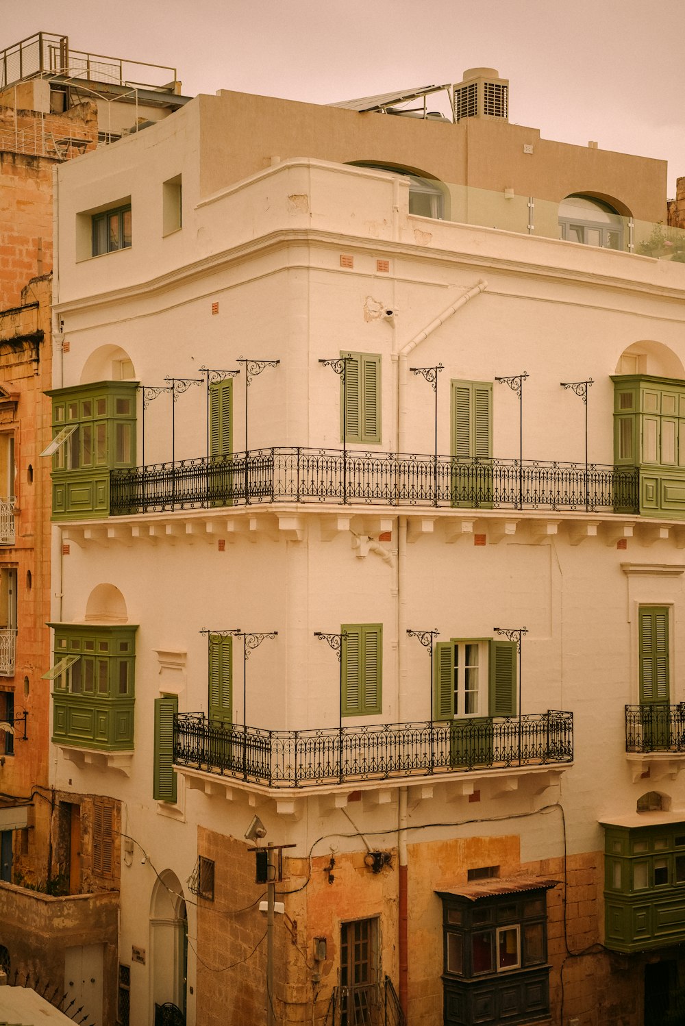 an old building with balconies and green shutters