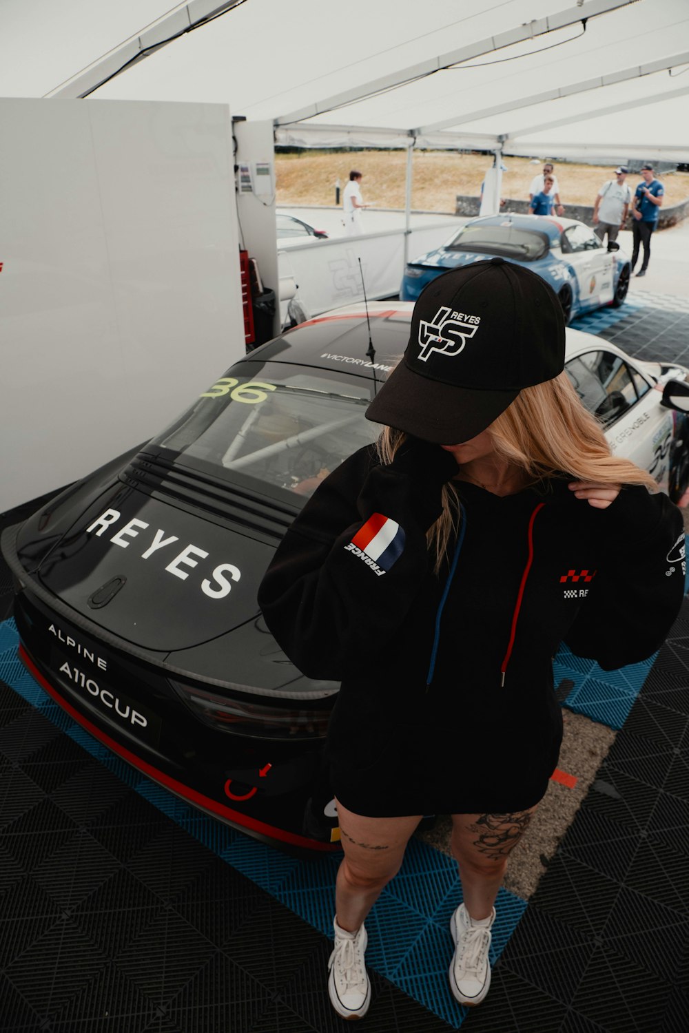 a woman standing next to a race car