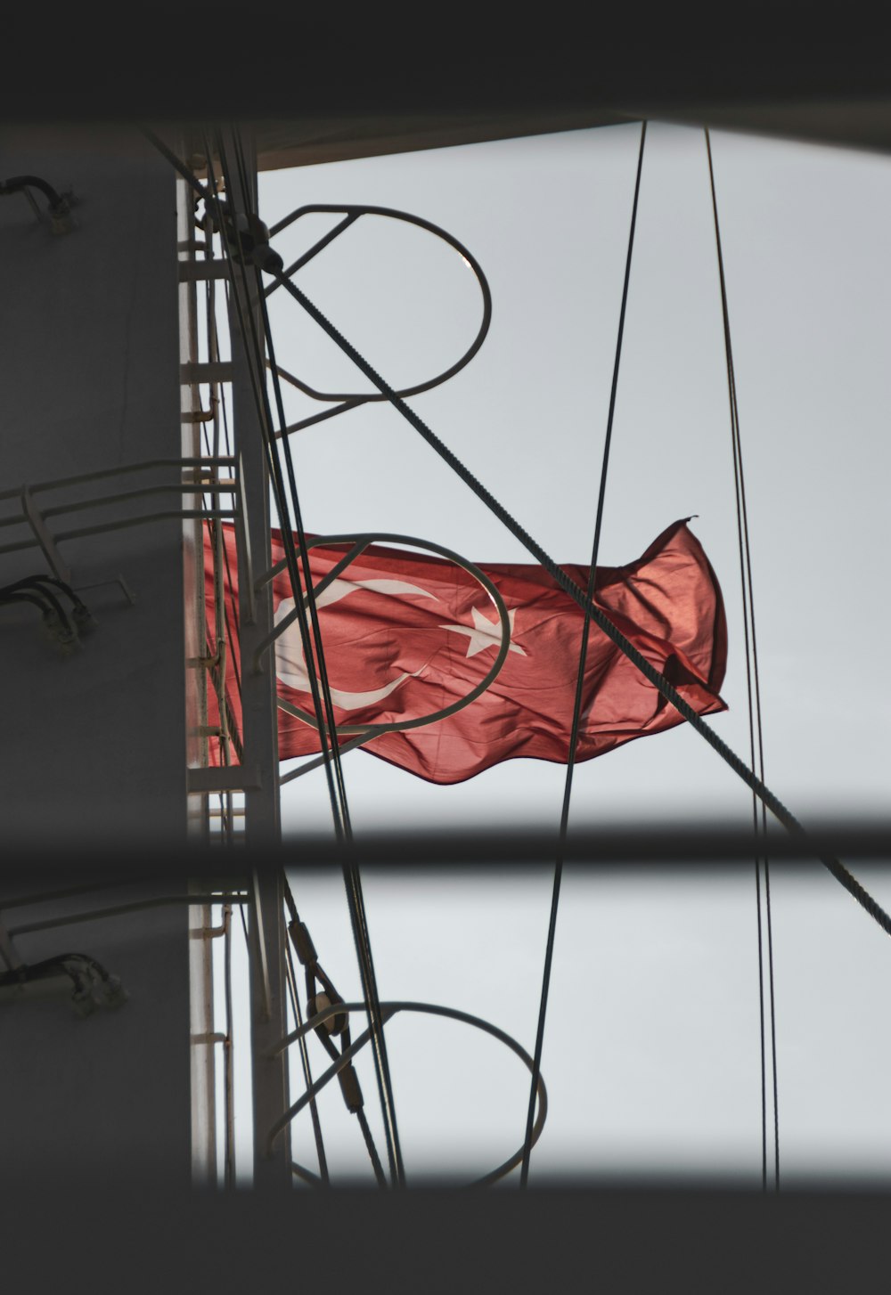 a red flag flying from the side of a boat