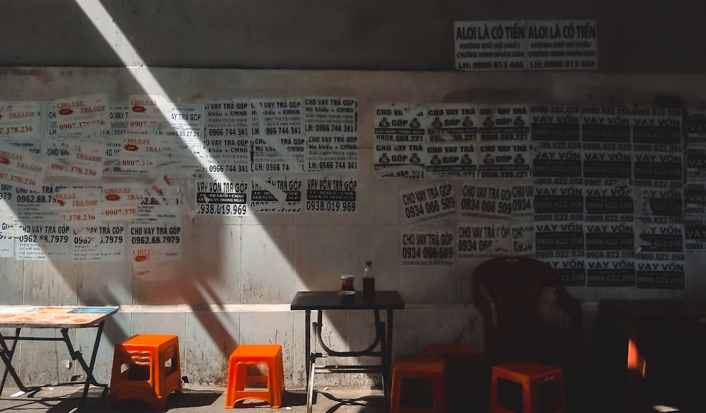 a table and chairs in front of a wall with writing on it
