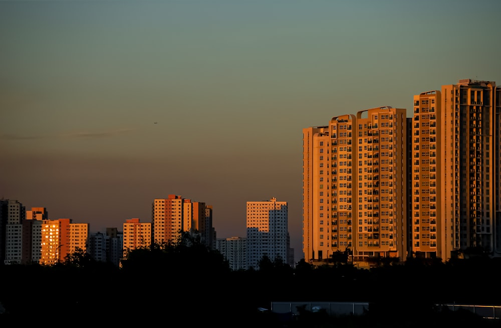 a city skyline with tall buildings at sunset