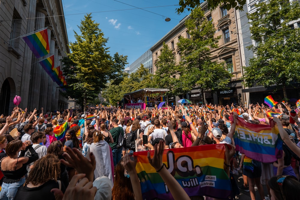 a large group of people holding rainbow flags