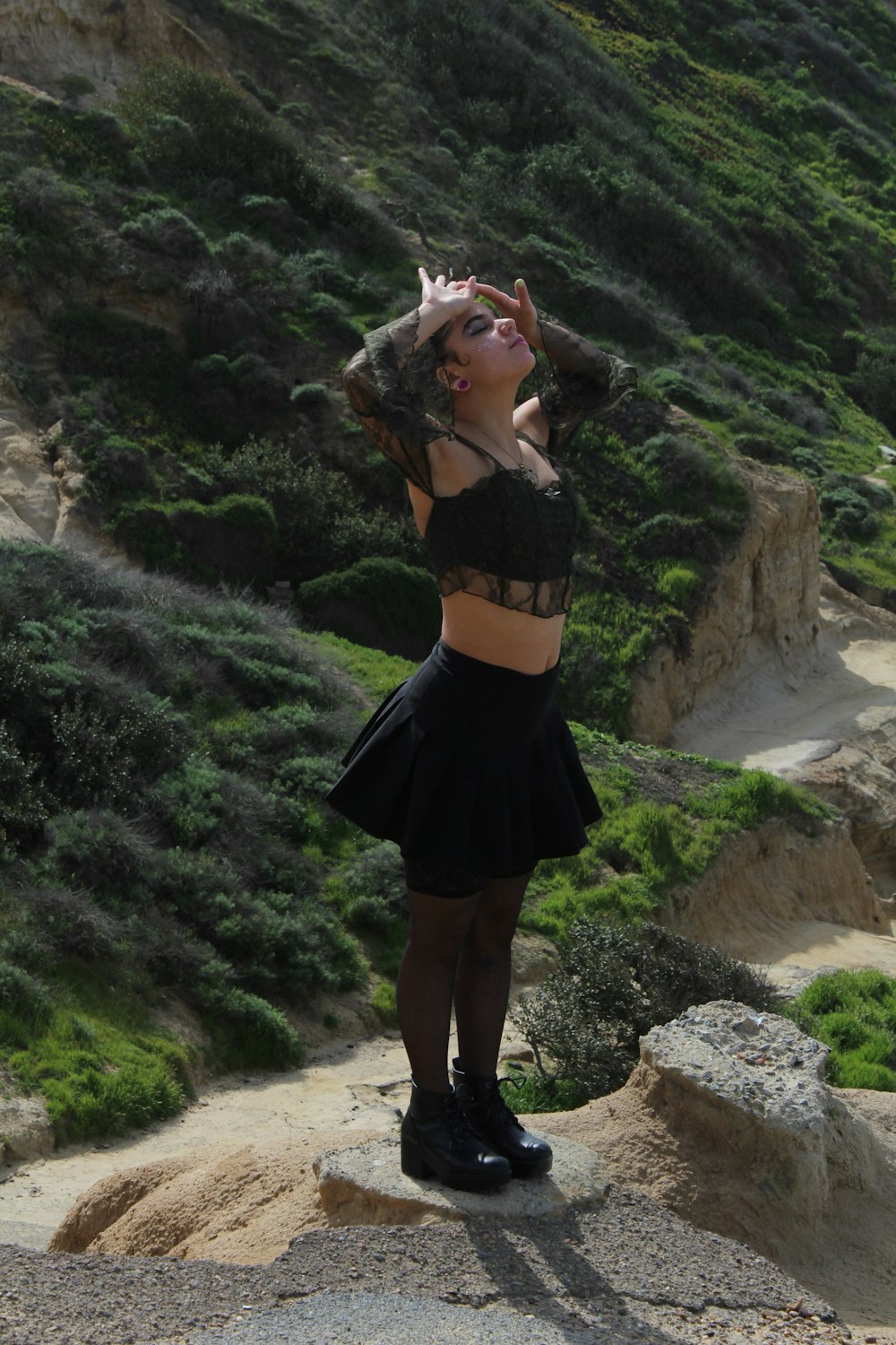 a woman standing on top of a rocky hillside