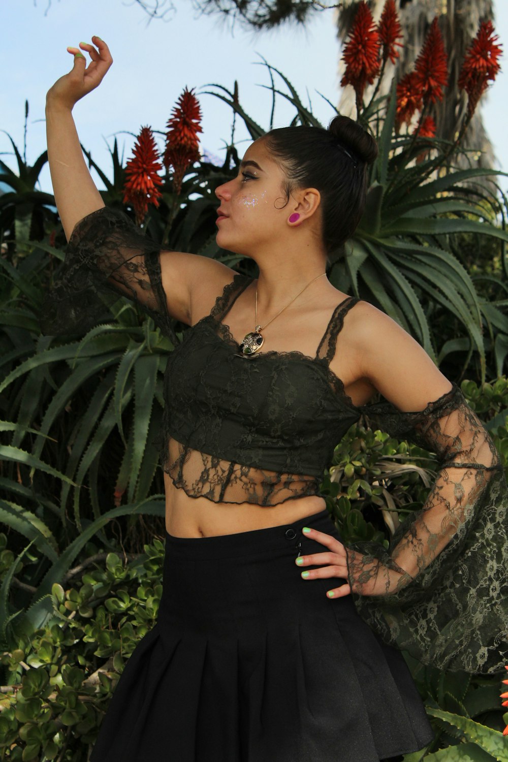 a woman wearing a black skirt and crop top