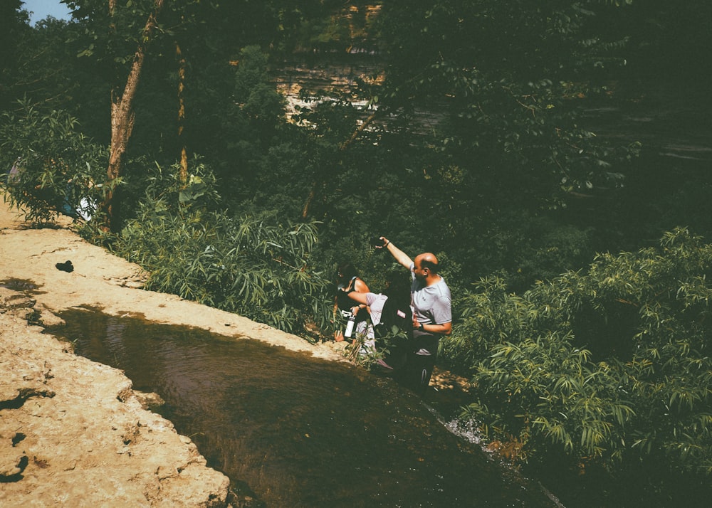 a group of people standing next to a river