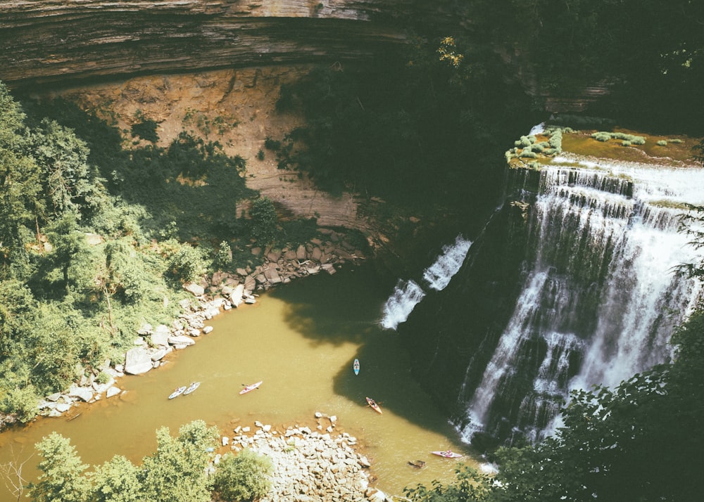 a group of people standing at the base of a waterfall