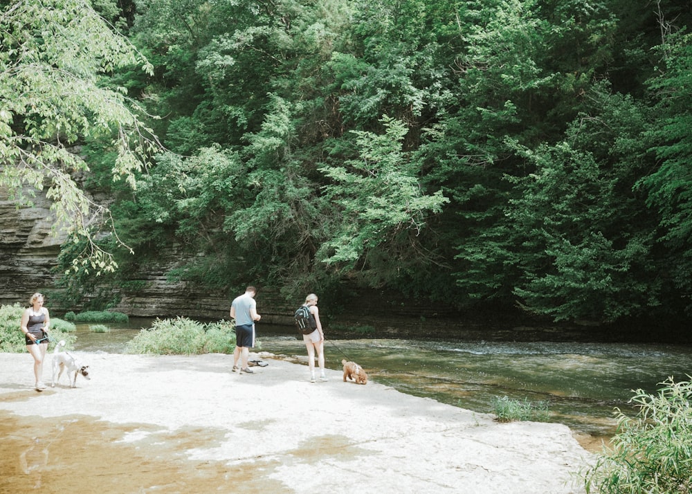 a group of people standing next to a river