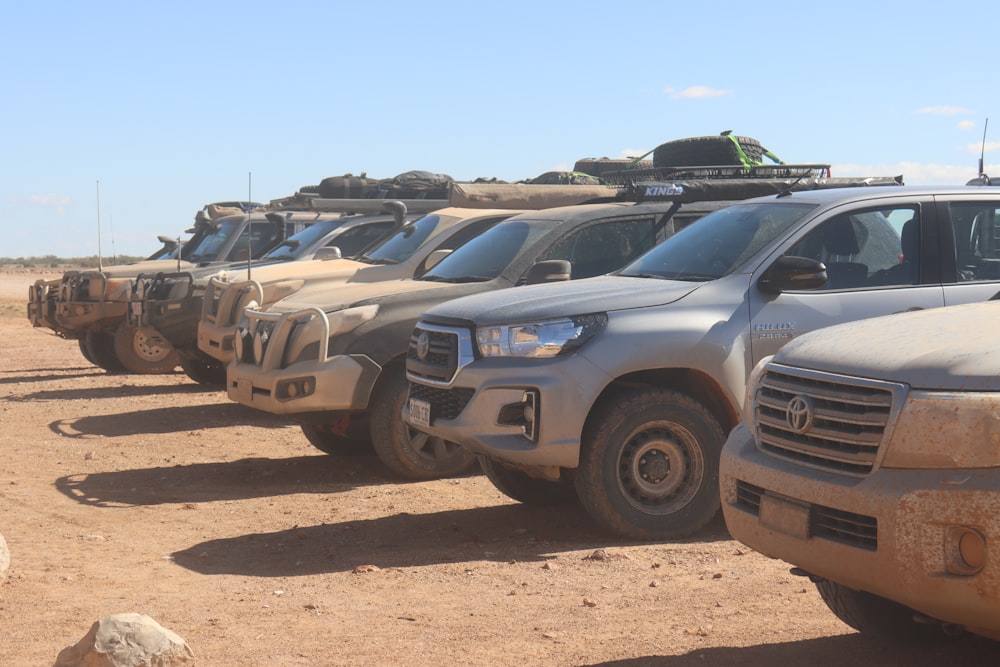 a bunch of trucks that are parked in the dirt