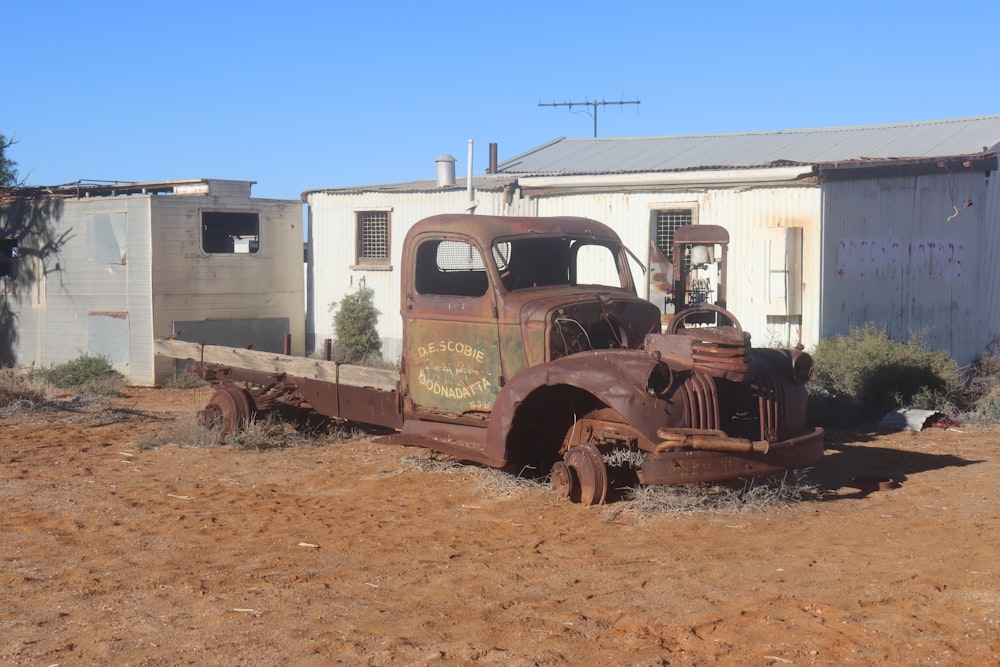 an old truck is parked in the dirt