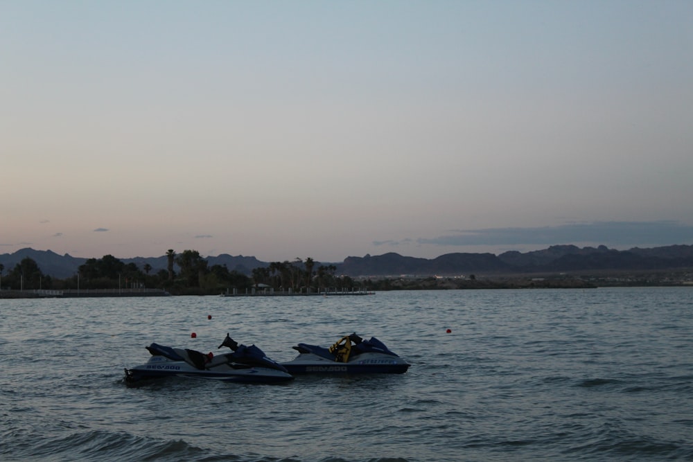 a couple of boats floating on top of a body of water