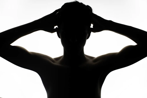 a silhouette of a man with his hands on his head