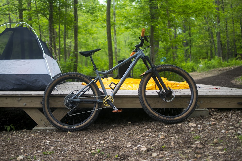 a bicycle parked on a wooden platform in the woods