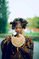 a woman in a traditional african dress holding a basket