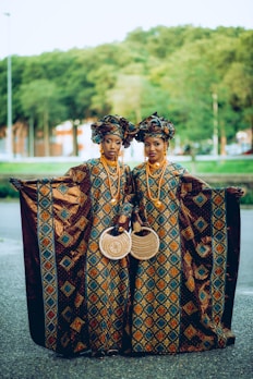 two women dressed in african clothing standing next to each other