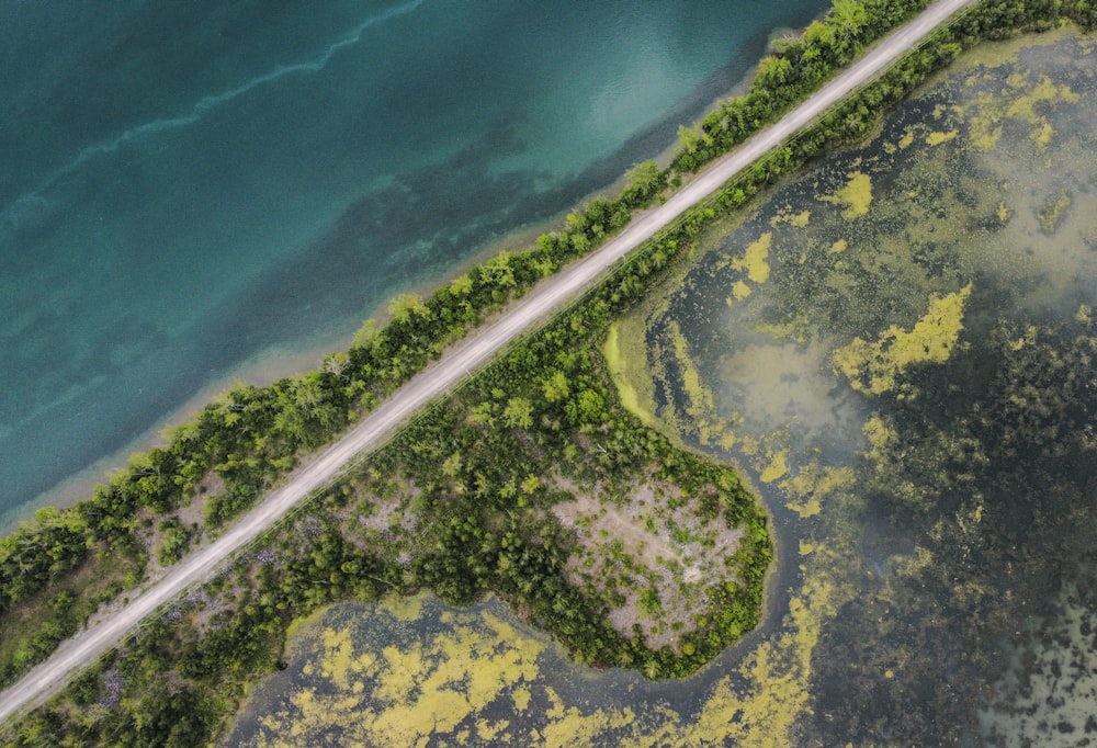 an aerial view of a road near a body of water