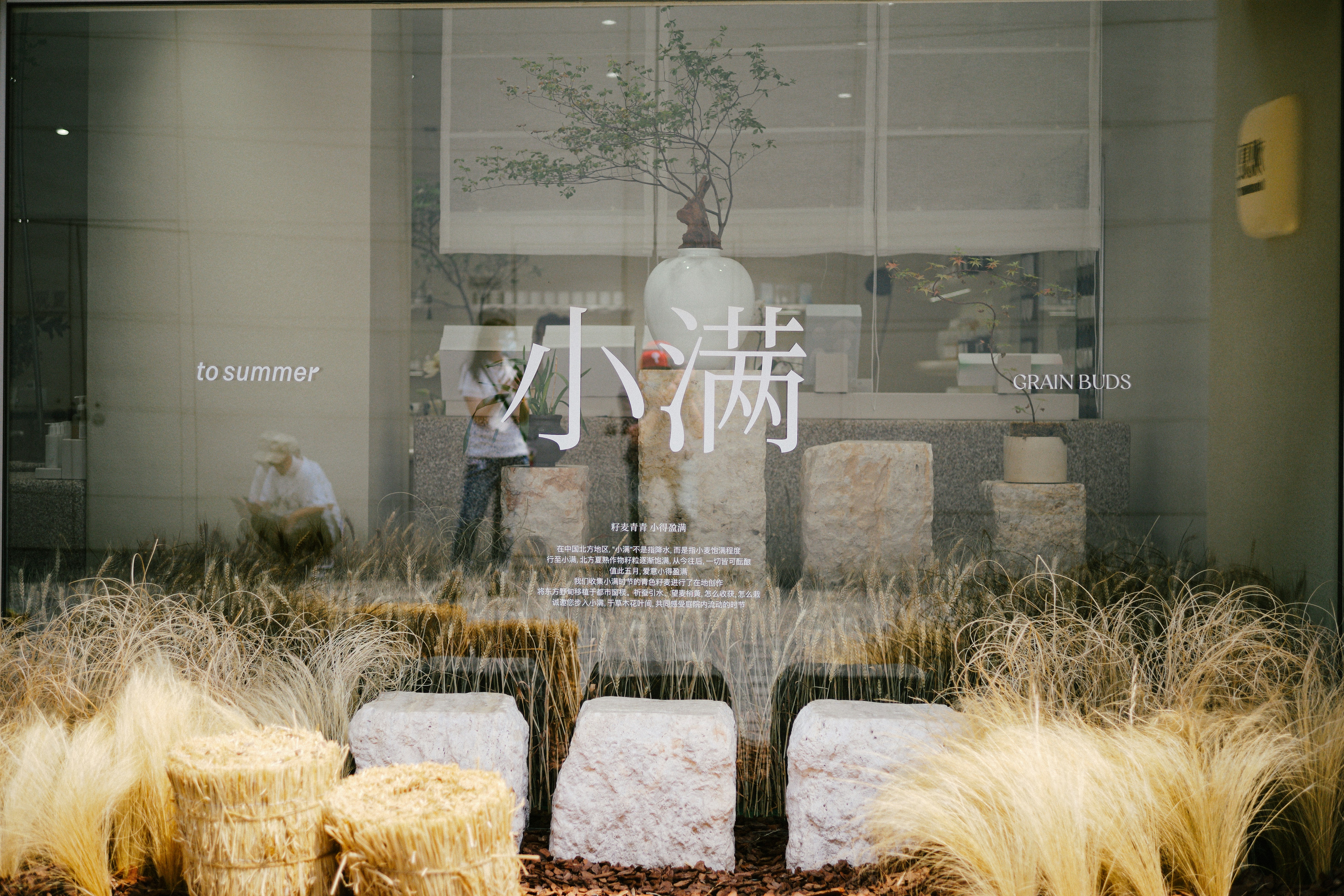 a store window with a bunch of hay in front of it
