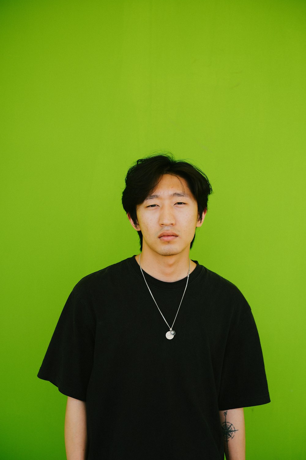 a man standing in front of a green wall