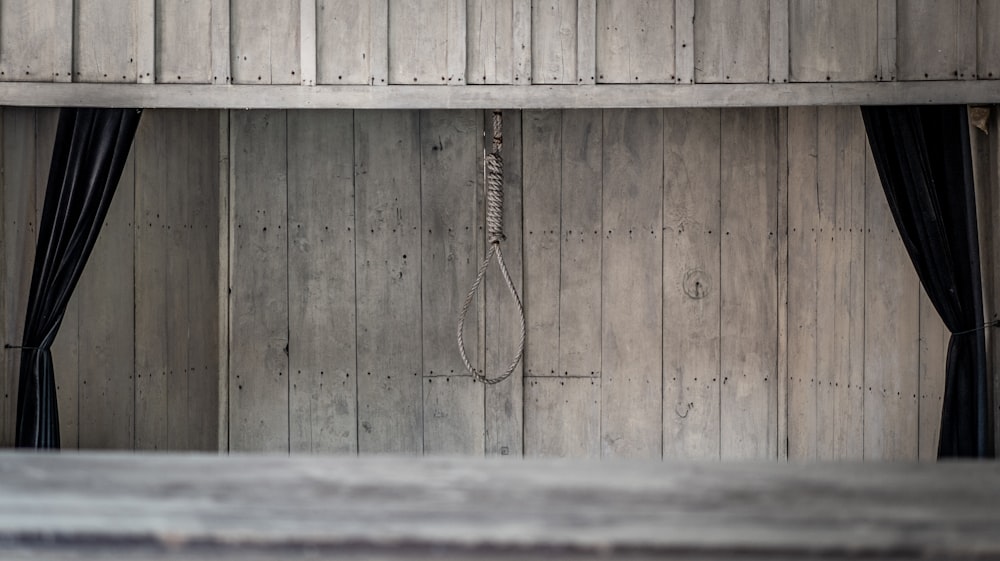 a room with wooden walls and black curtains