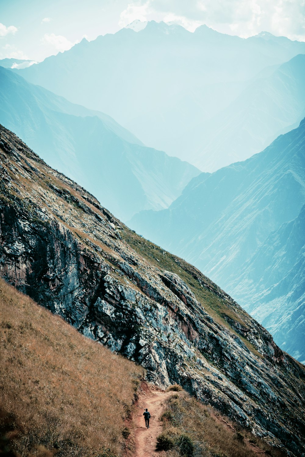 a person walking up a trail in the mountains