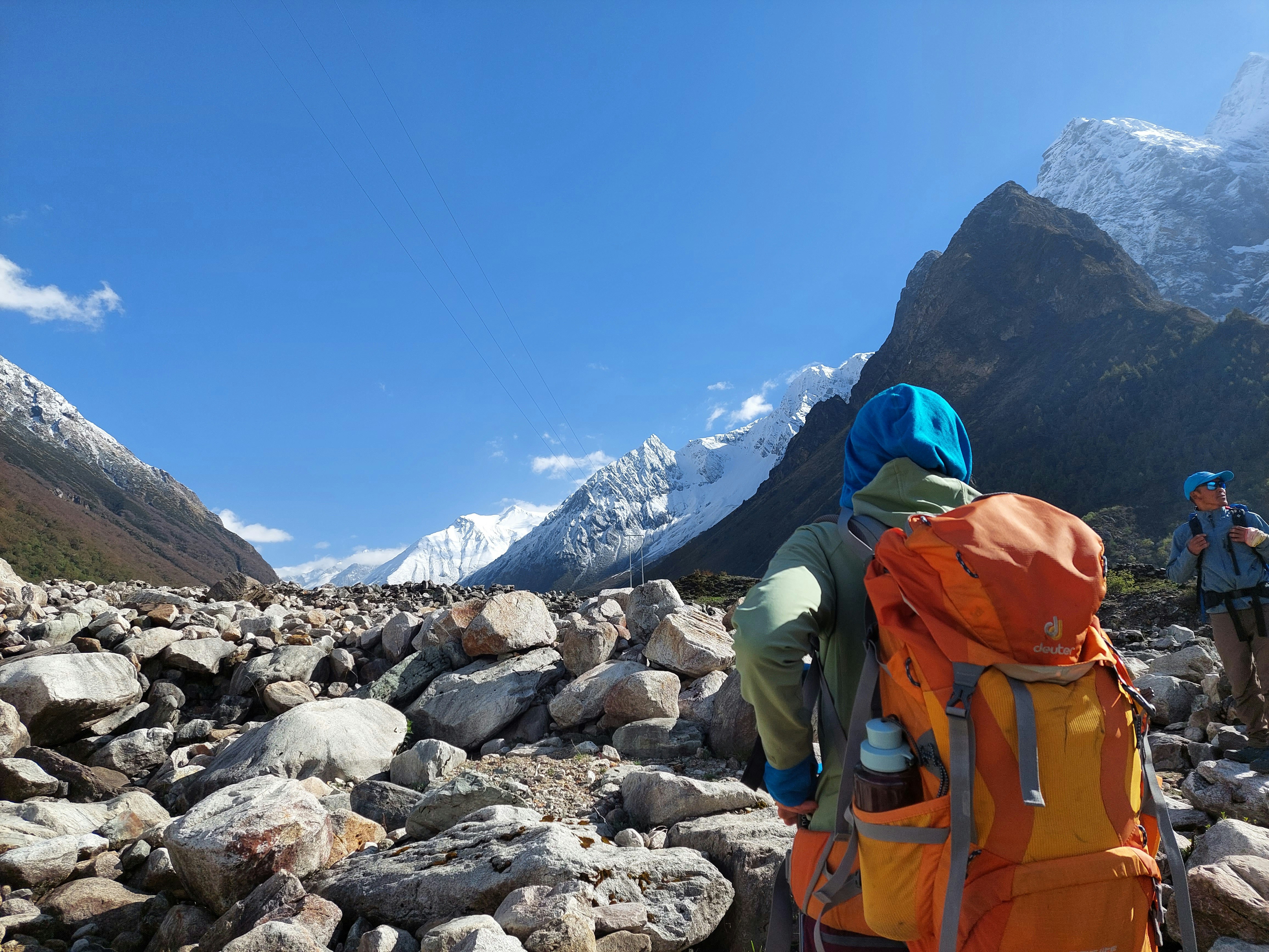 a couple of people walking across a rocky field
