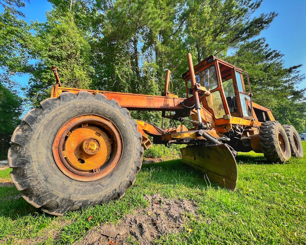 a tractor is parked in the grass near a tree