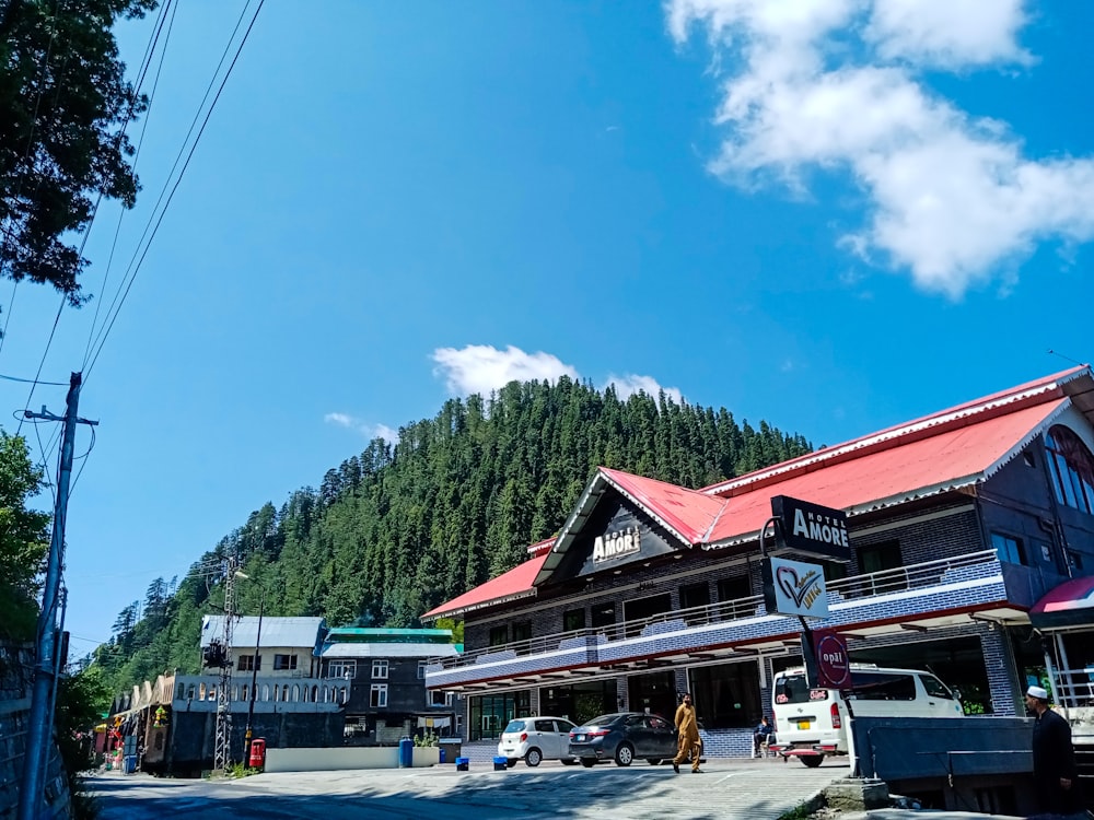 a building with a red roof next to a forest