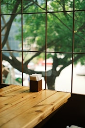 a wooden table sitting next to a window