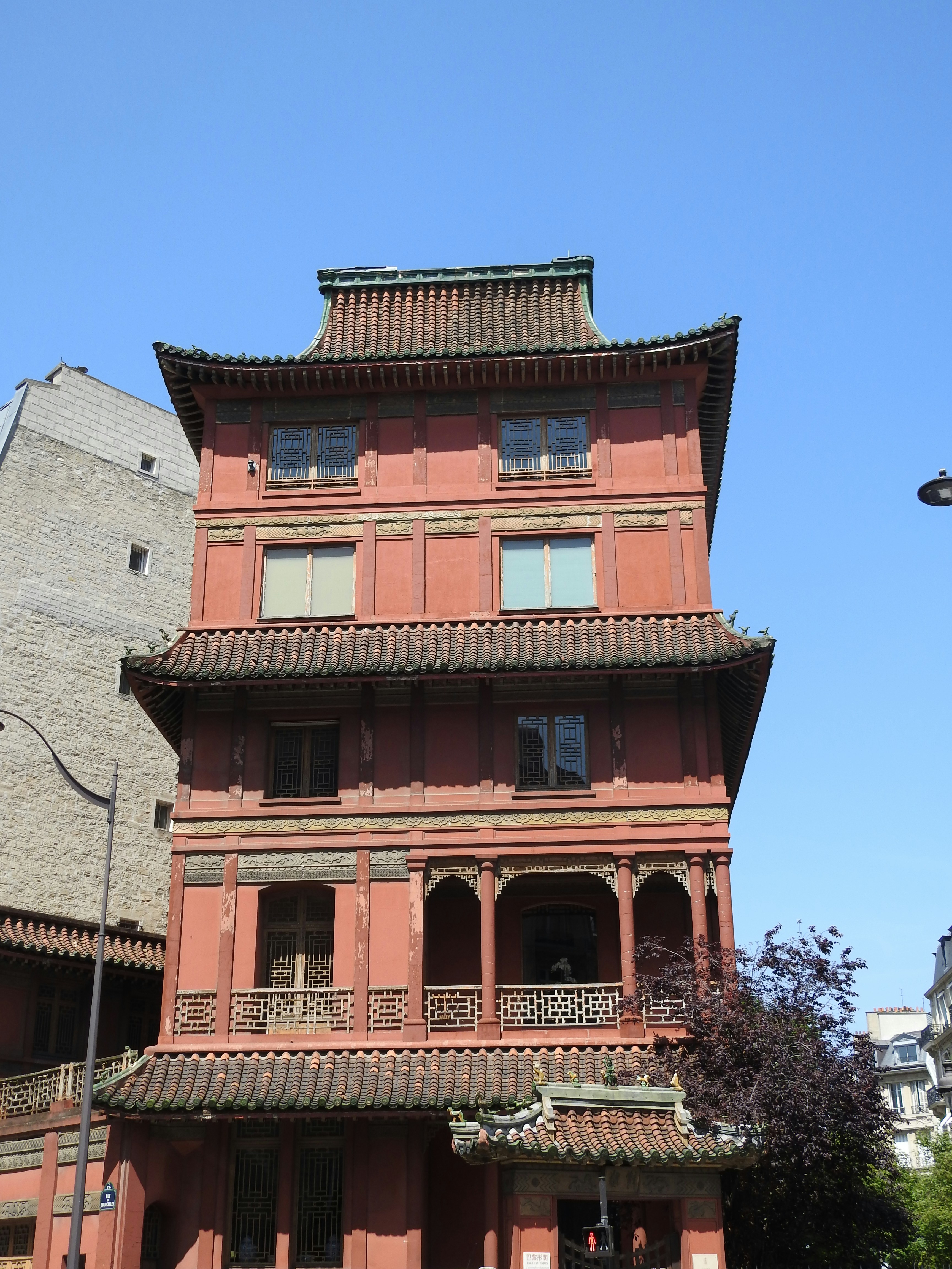 a tall red building with a clock on it's side