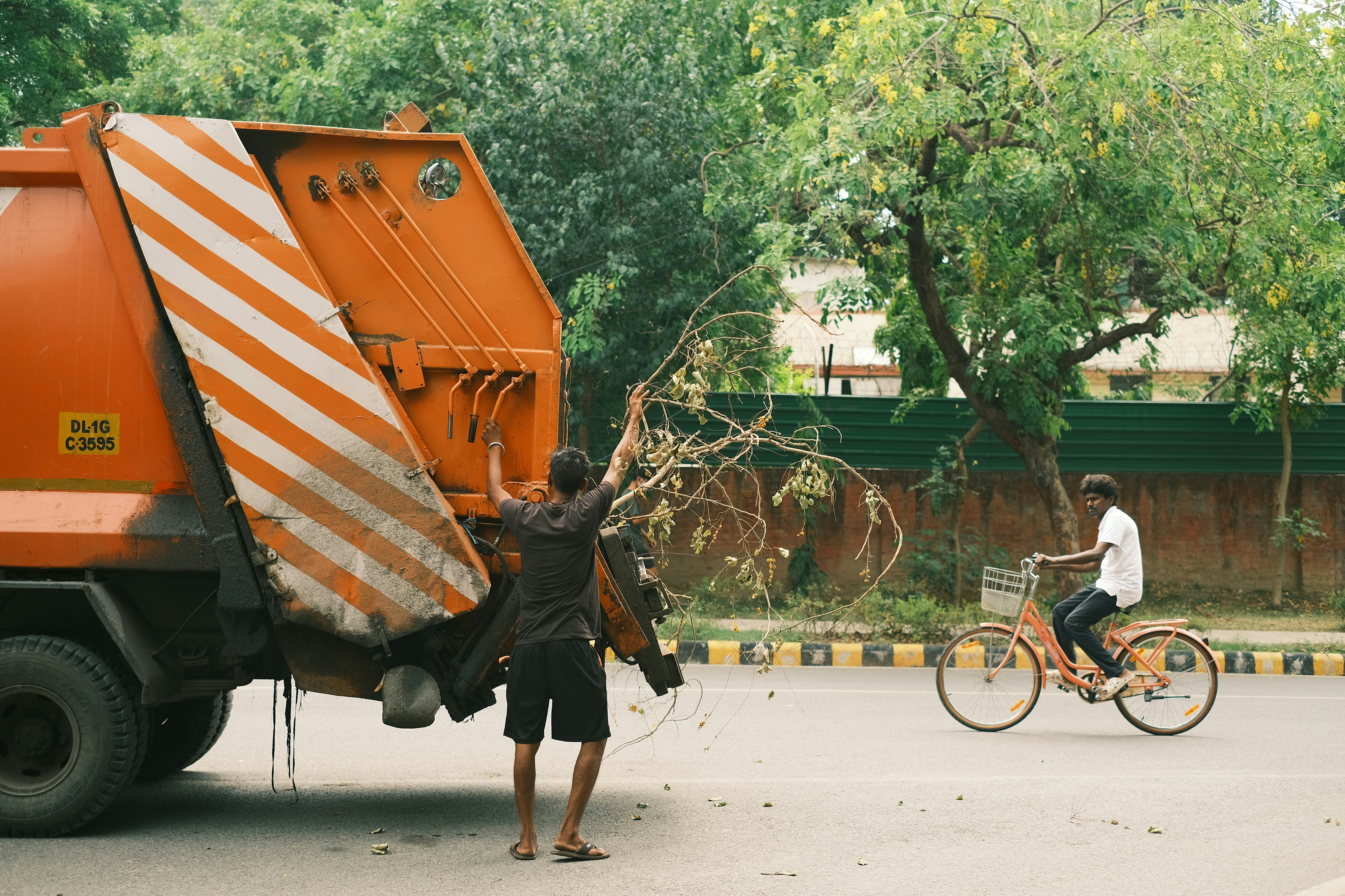 a man riding a bike next to a large orange truck