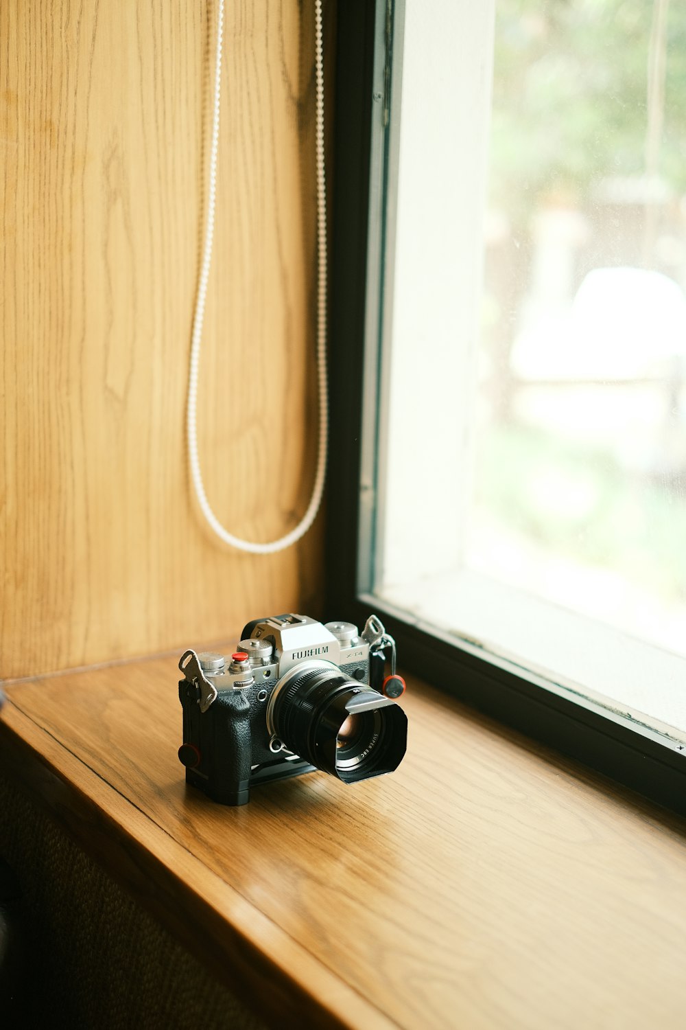 a camera sitting on a window sill next to a window