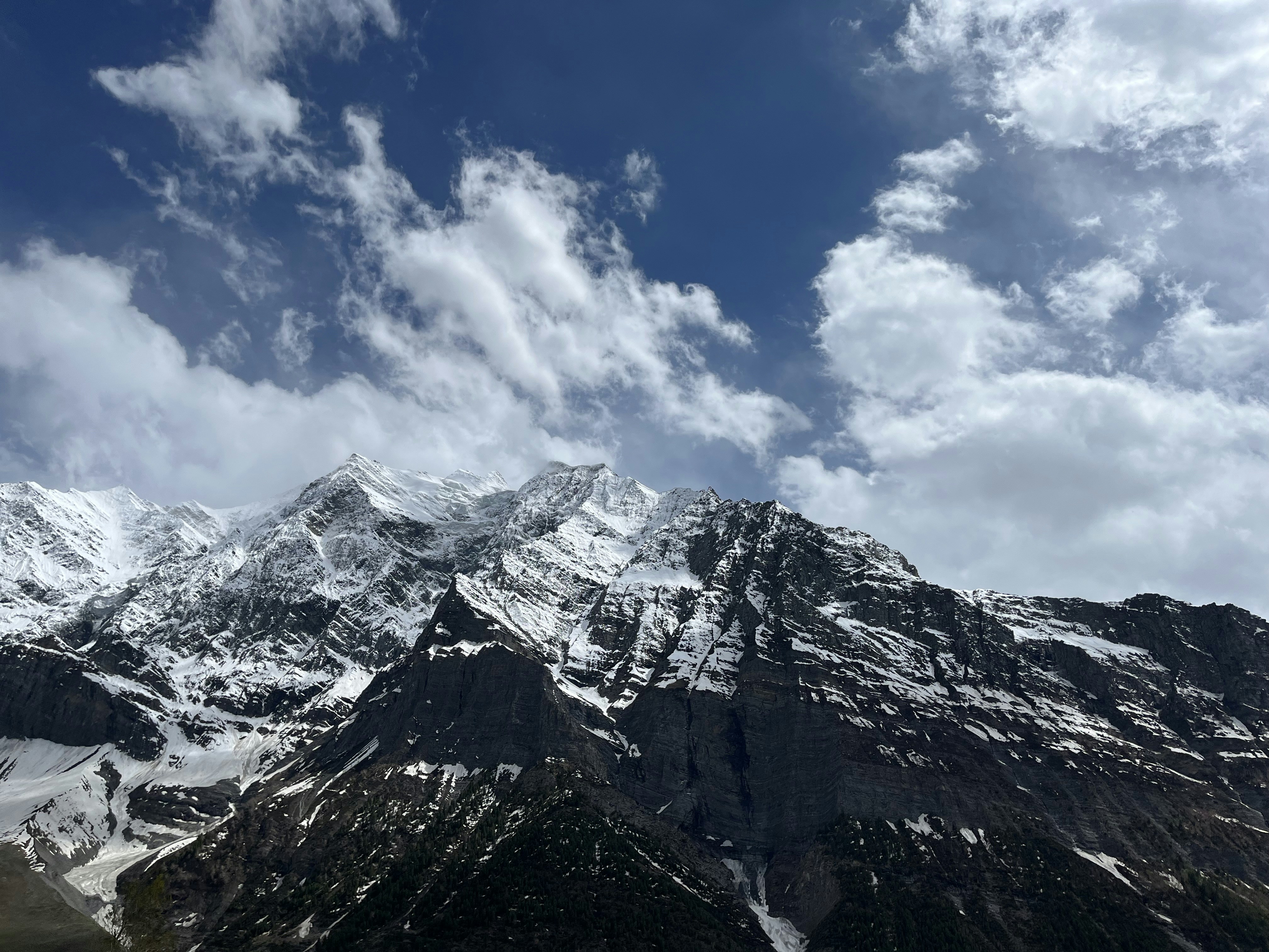 A snow covered mountain range under a partly cloudy sky photo – Free ...