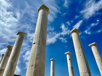 a group of tall white pillars under a blue sky