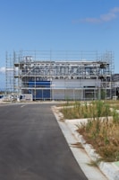 Workers laying foundations for a modern building on a cleared site.