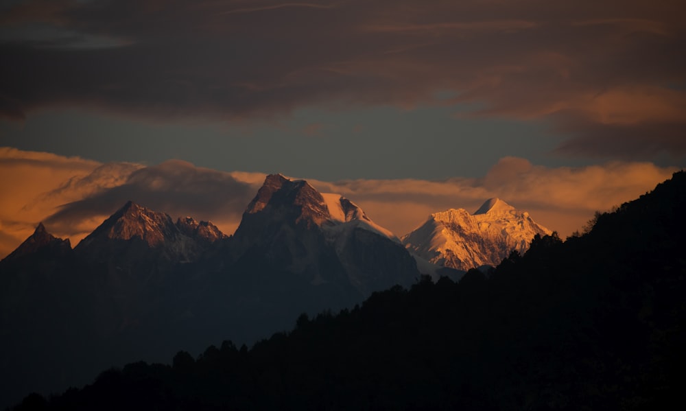 a mountain range with a few clouds in the sky