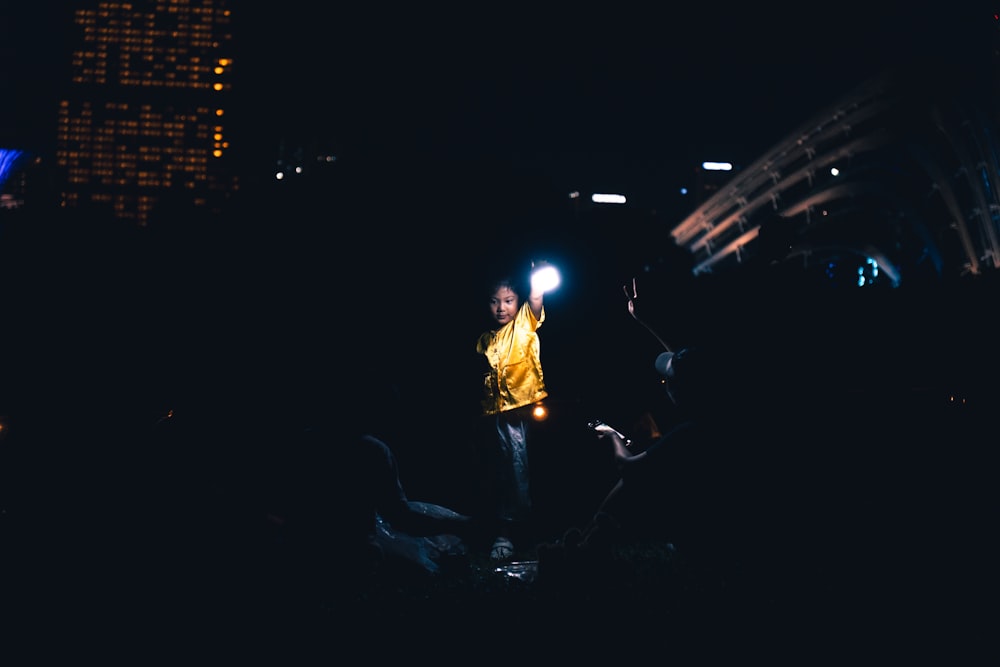 a man standing in the dark holding a cell phone