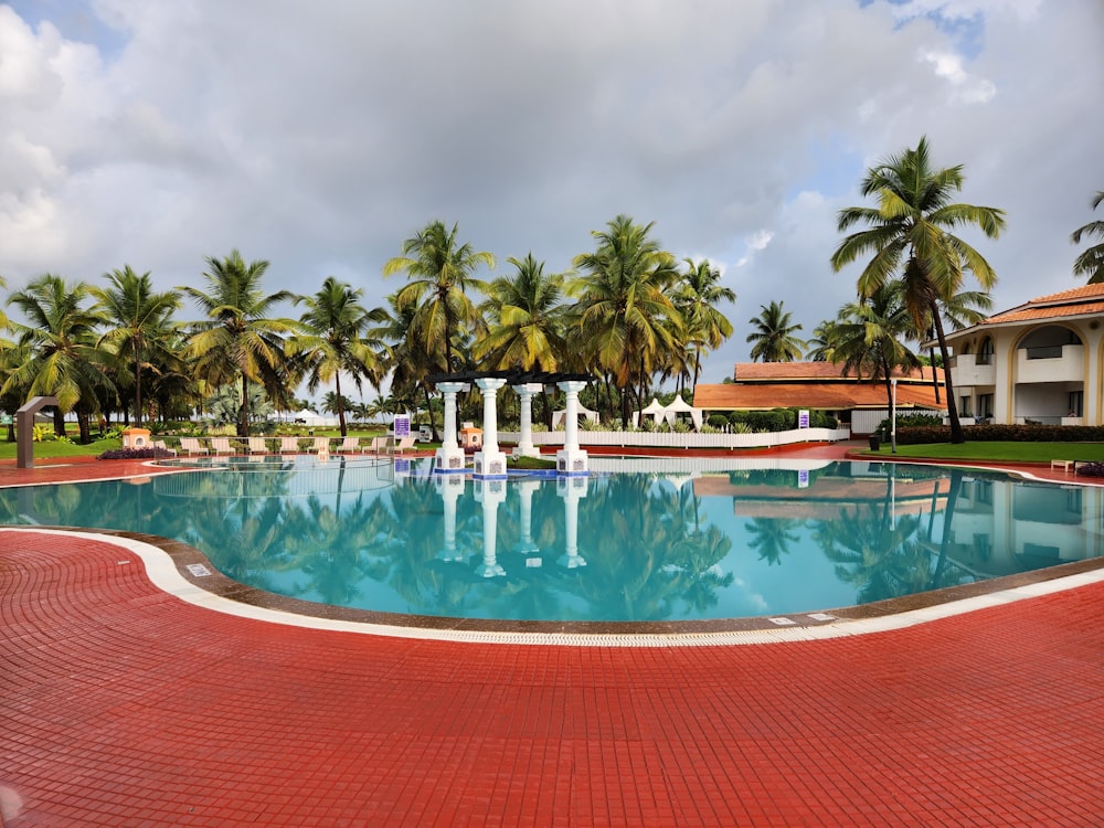 a large swimming pool surrounded by palm trees