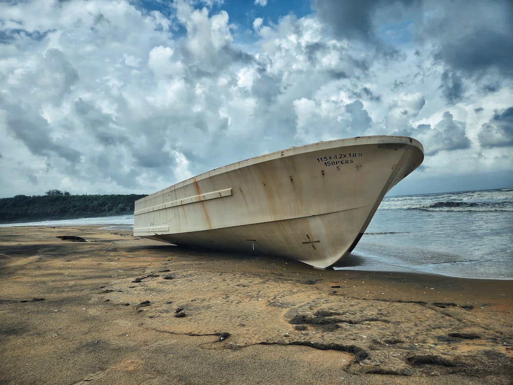 a boat sitting on top of a sandy beach