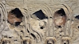 Aerial view of construction site soil with distinct tire tread patterns and uneven terrain. The surface shows a variety of textures and shades, primarily composed of light earth tones.