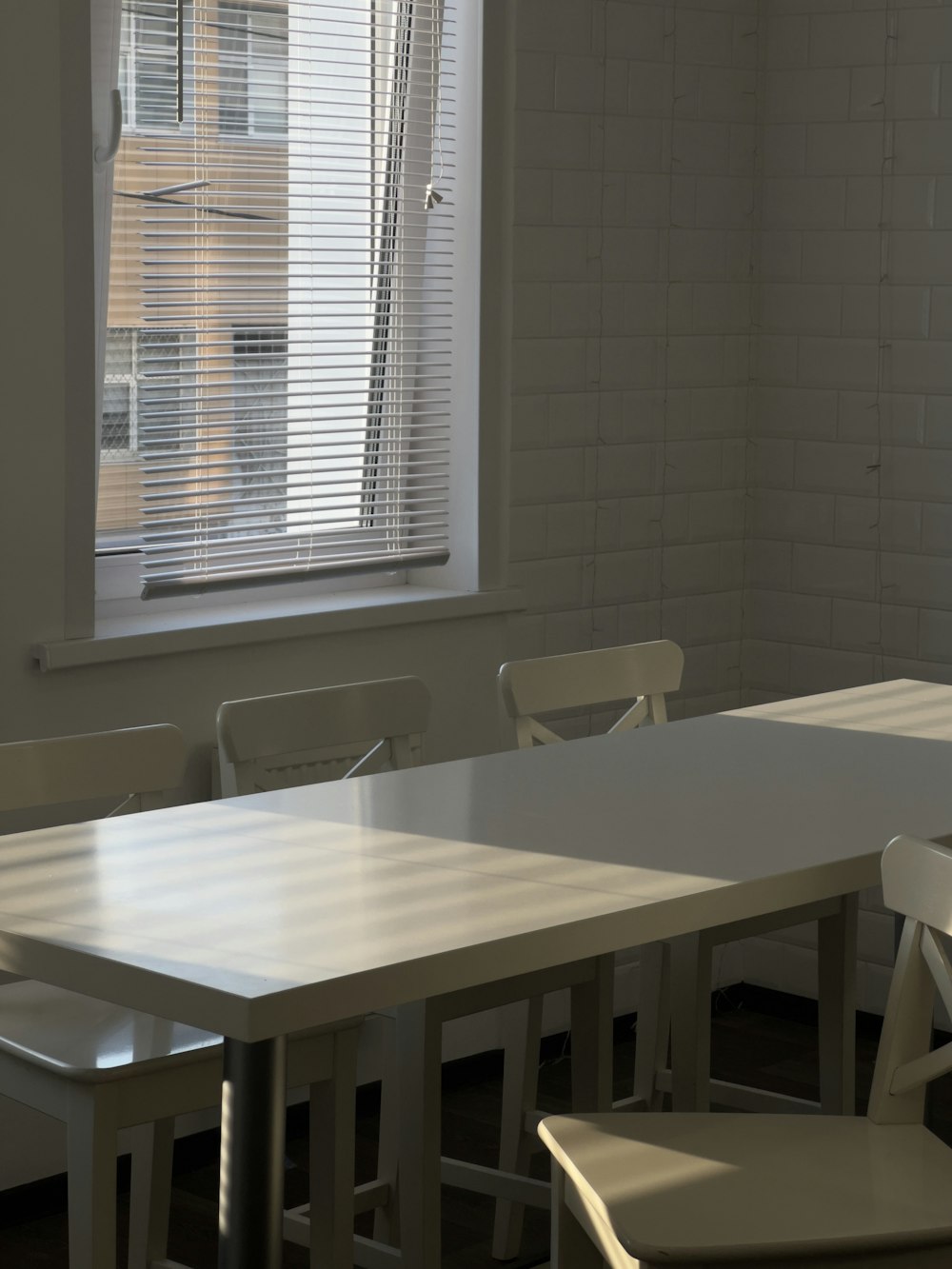 a table and chairs in a room with a window