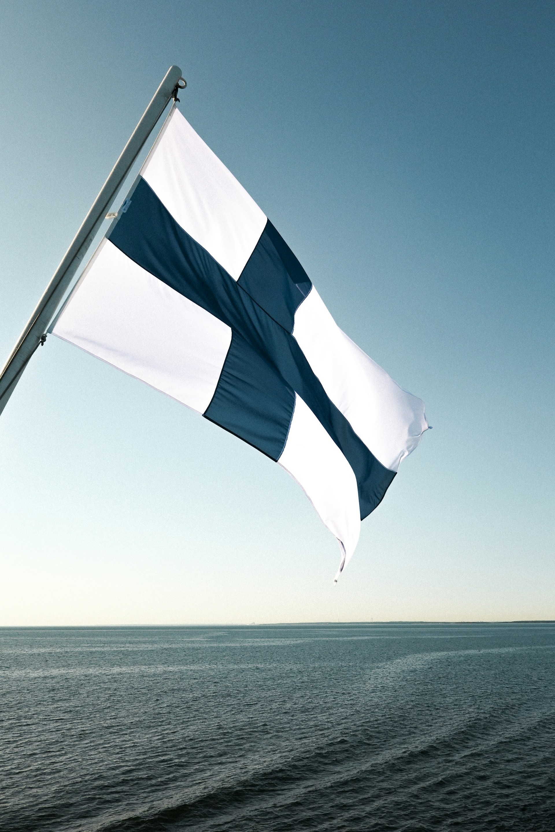 a blue and white flag flying over a body of water