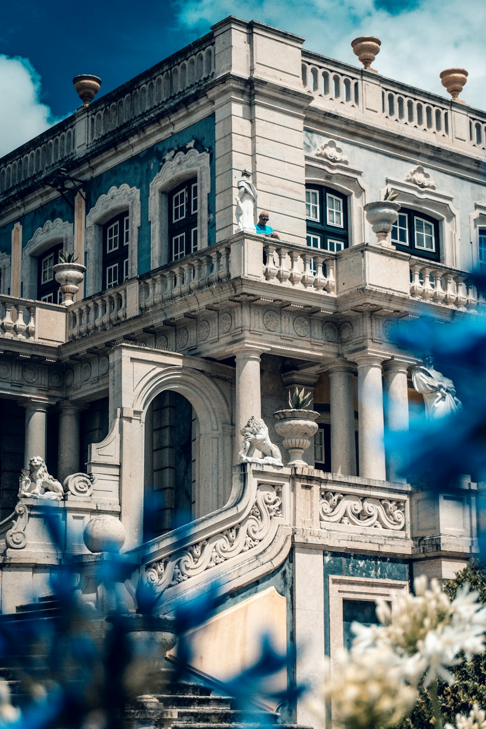 un grand bâtiment blanc avec une horloge sur le dessus