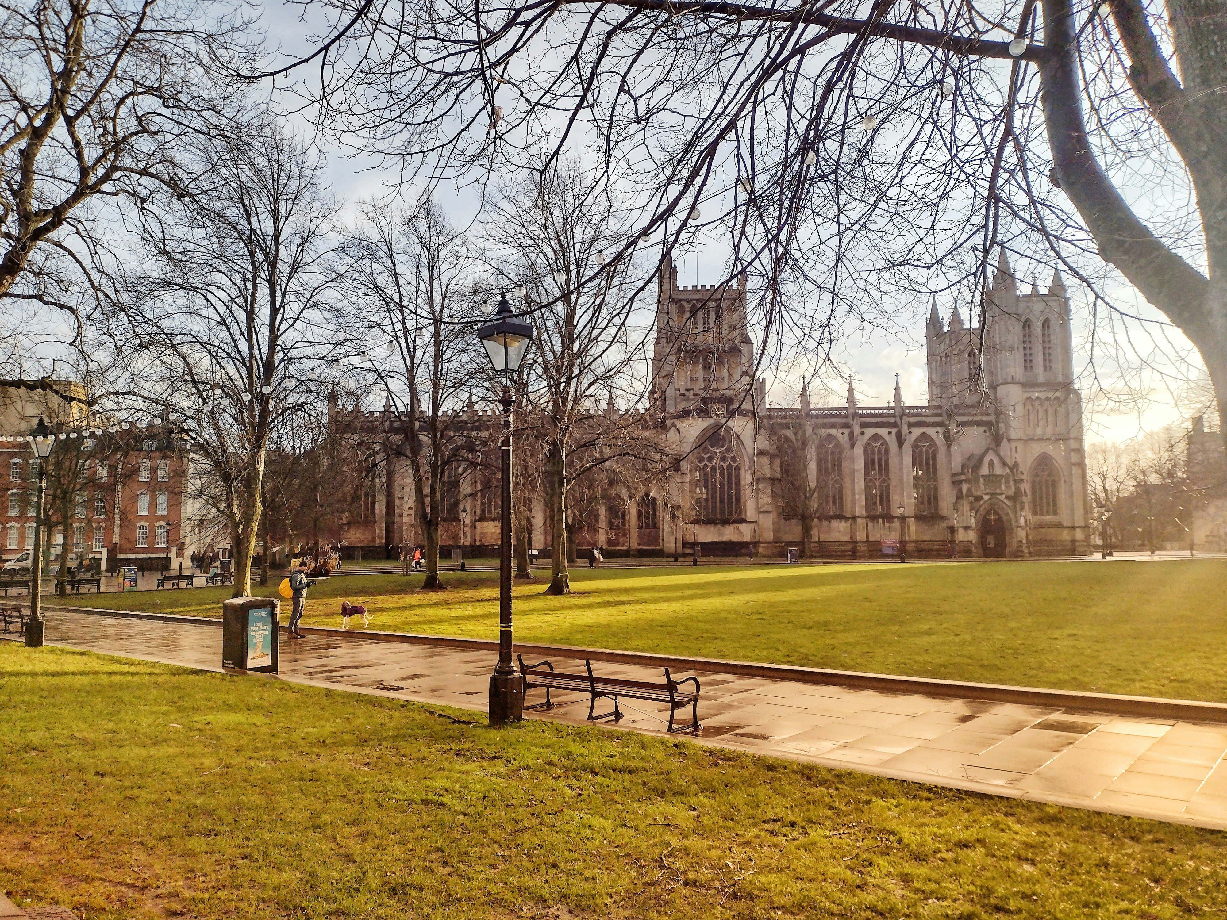 a park with a bench and a church in the background