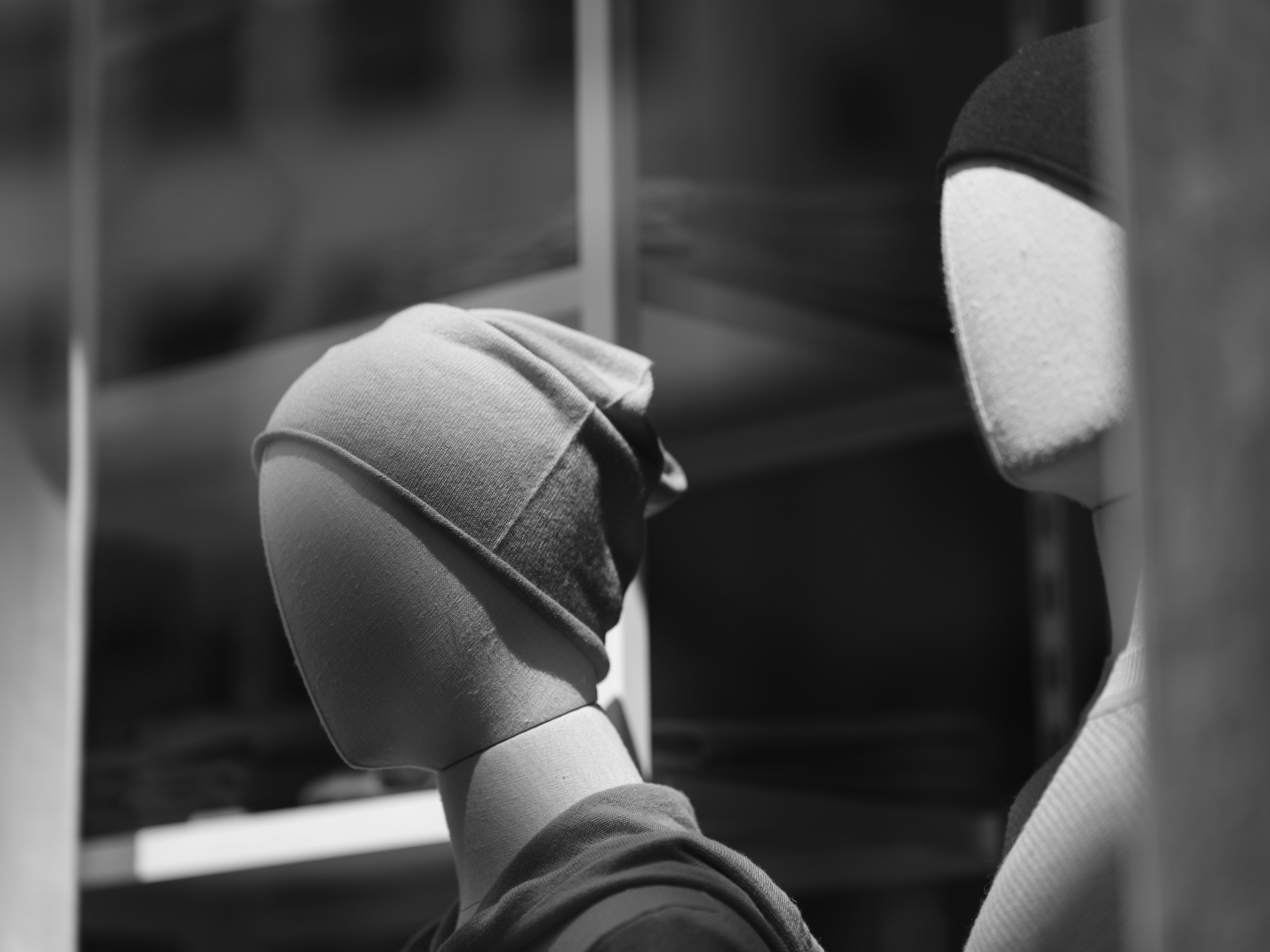 a mannequin's head wearing a hat in front of a mirror