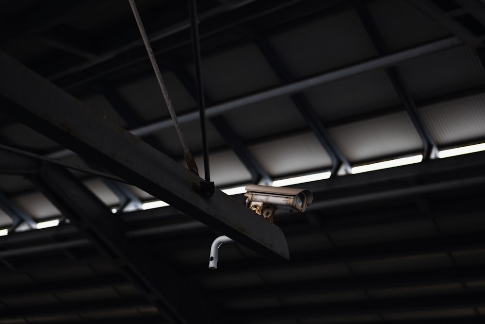uma câmera de segurança pendurada no teto de um prédio;