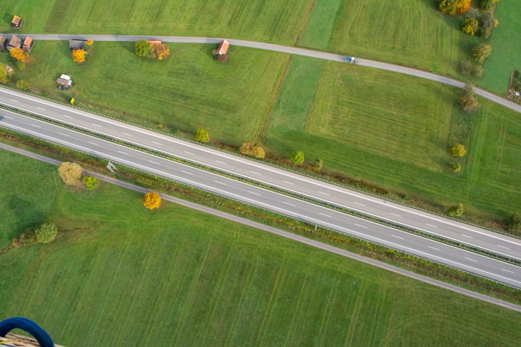 an aerial view of a highway and a field